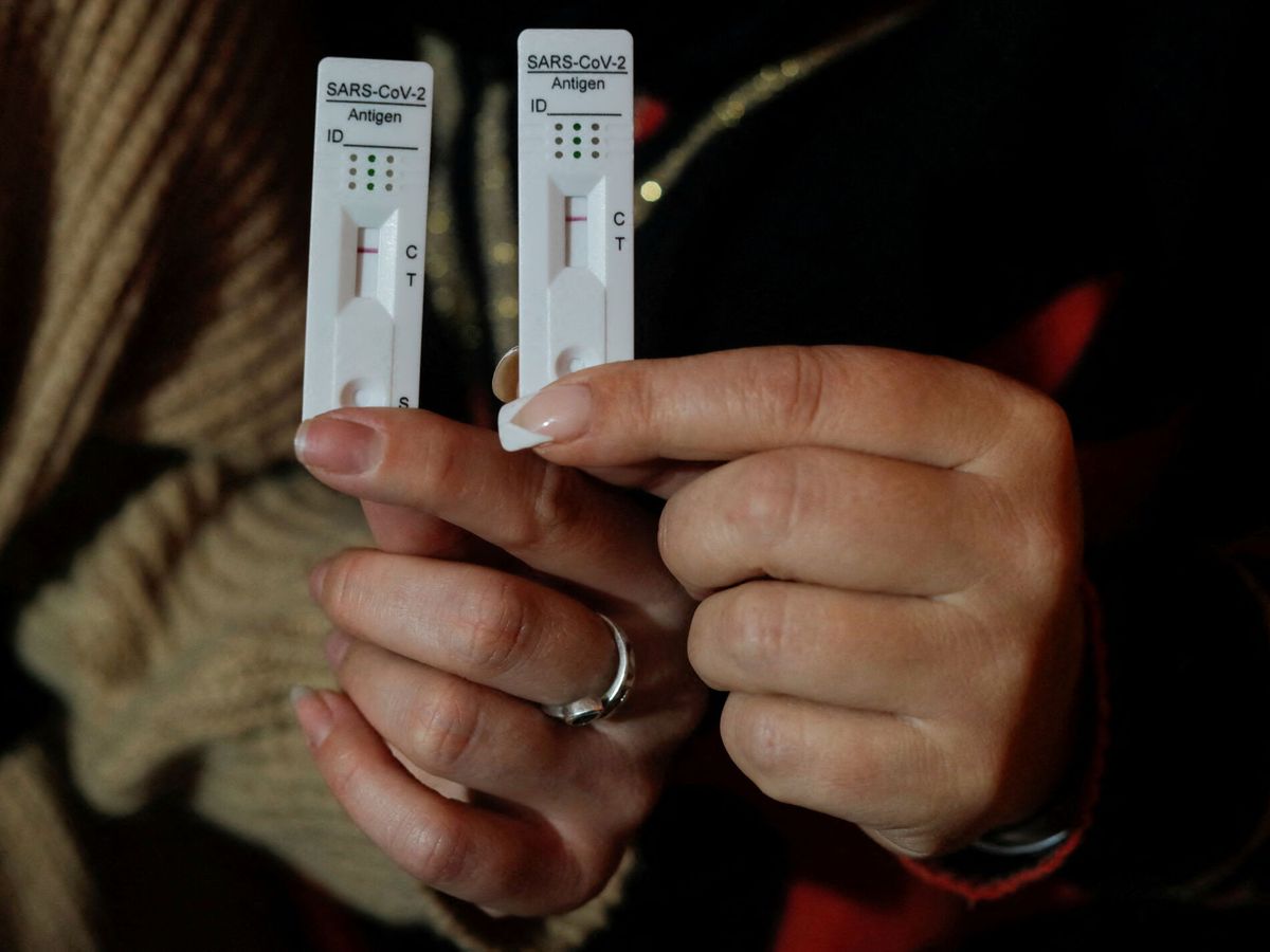 Foto: Dos personas muestran el resultado negativo de su test de antígenos. (Reuters/Jon Nazca)