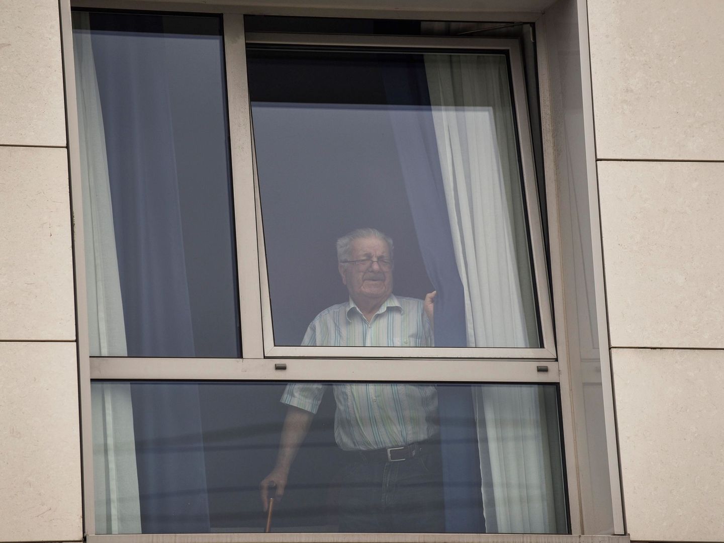 Un usuario se asoma a la ventana en una residencia de mayores. (EFE)