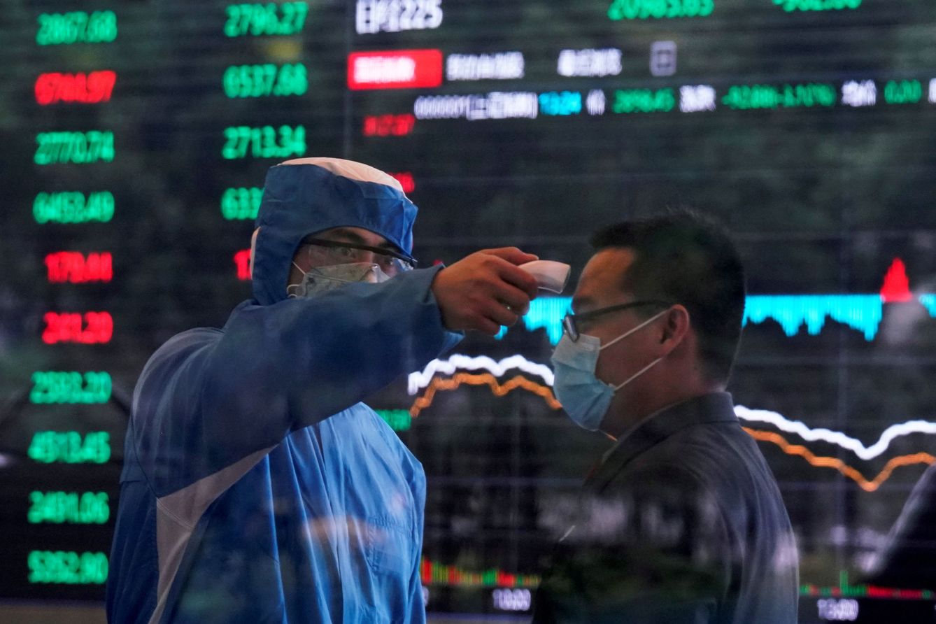 Un médico toma la temperatura a una persona en el interior de la Bolsa de Shanghái. (Reuters)