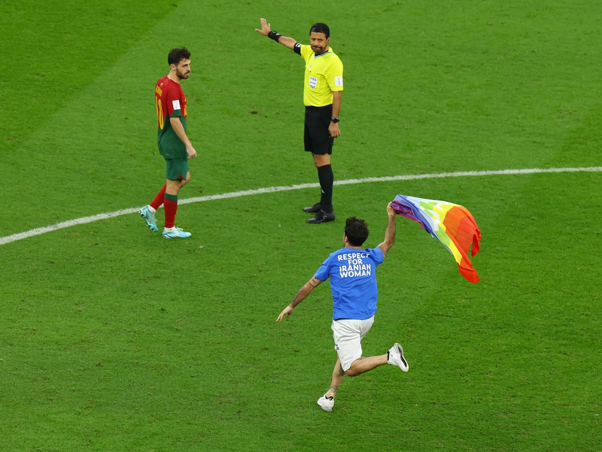 Foto: Un espontáneo salta al césped del Mundial de Qatar con una bandera LGTBI y una camiseta reivindicativa. (Reuters)