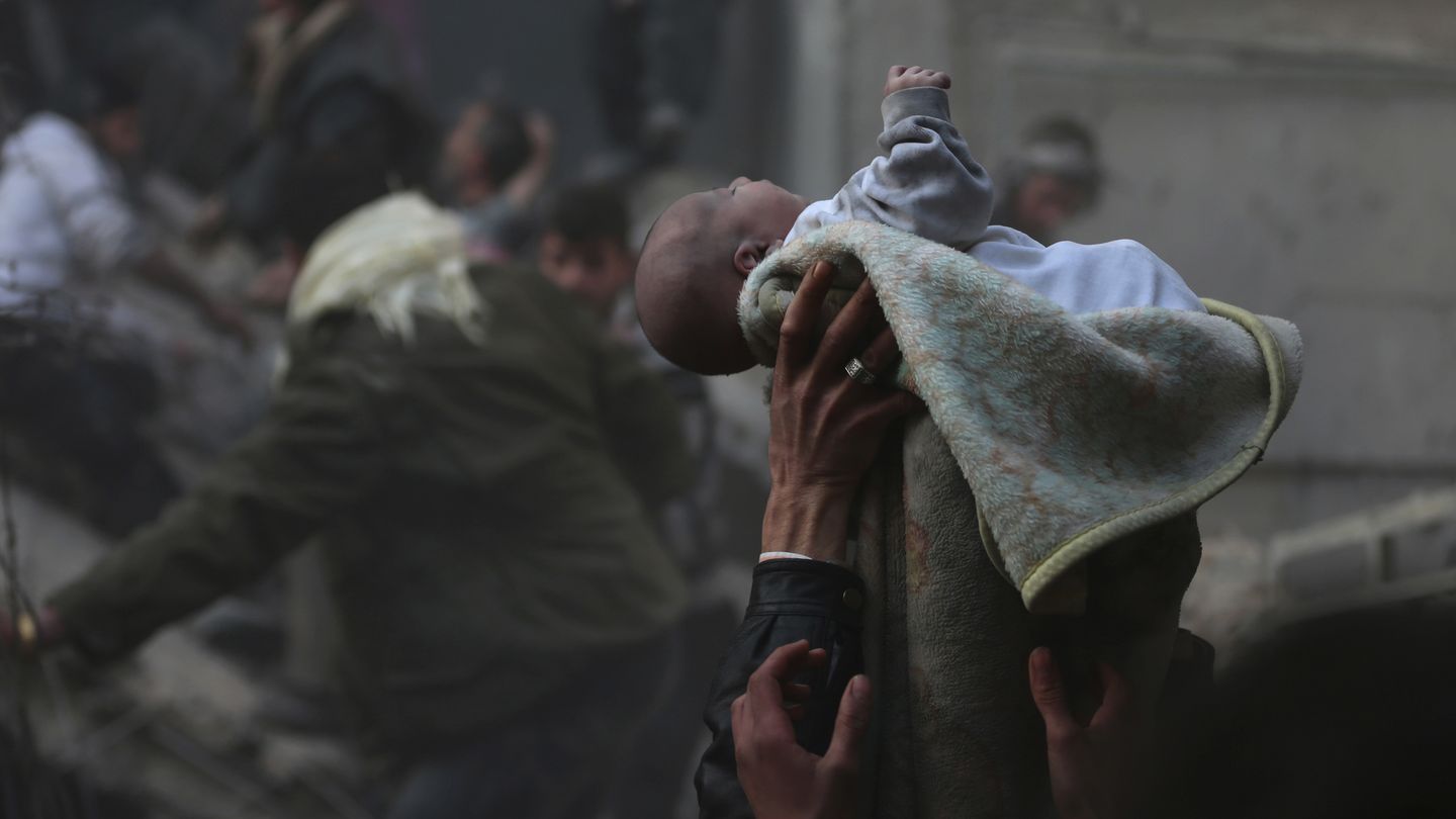 Un bebé rescatado de entre los escombros tras un bombardeo en Duma, Damasco (Reuters).