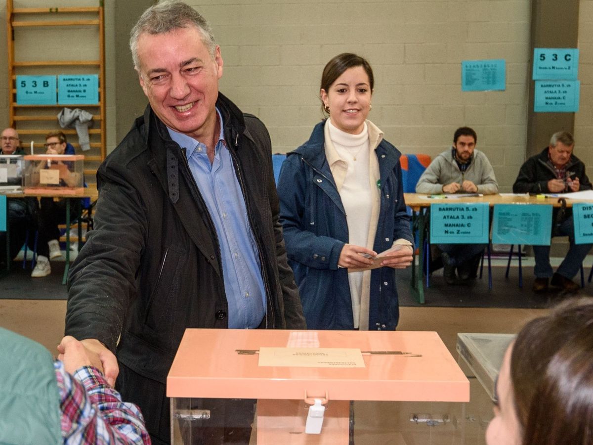 Foto: Urkullu da un apretón de manos a un integrante de la mesa tras votar en unas elecciones. Esta imagen no podrá darse en las elecciones vascas del 12 de julio. (EFE)