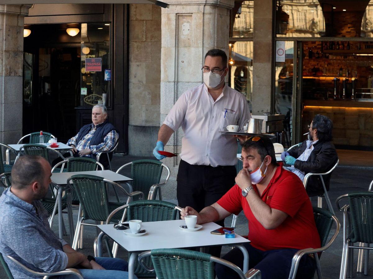 Foto: Un camarero sirve a los clientes en su bar de la plaza Mayor de Salamanca. (EFE)