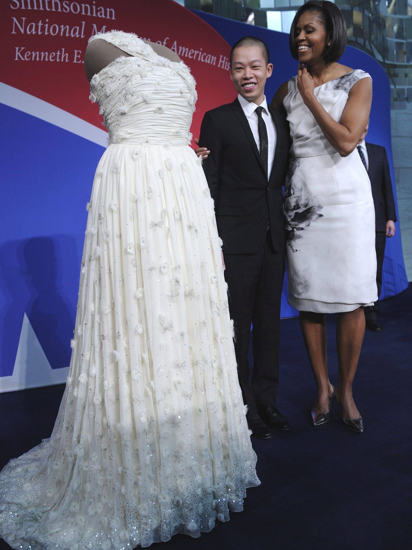 Michelle Obama y el diseñador Jason Wu,  junto al vestido que lució durante los bailes inaugurales de la presidencia de su marido. (EFE)