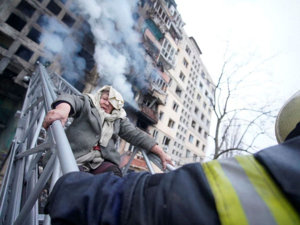Foto: Evacuación de una mujer de un edificio en llamas en Kiev. (Reuters/Servicios de Emergencia)