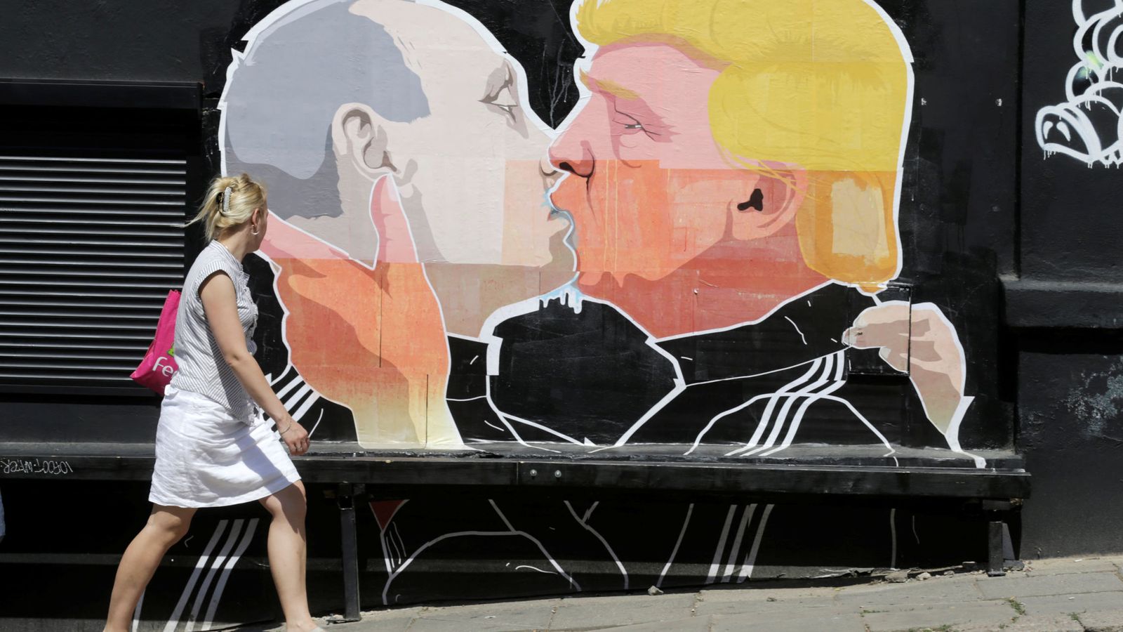 Foto: Una mujer pasa frente a un graffiti en Vilnius (Reuters)