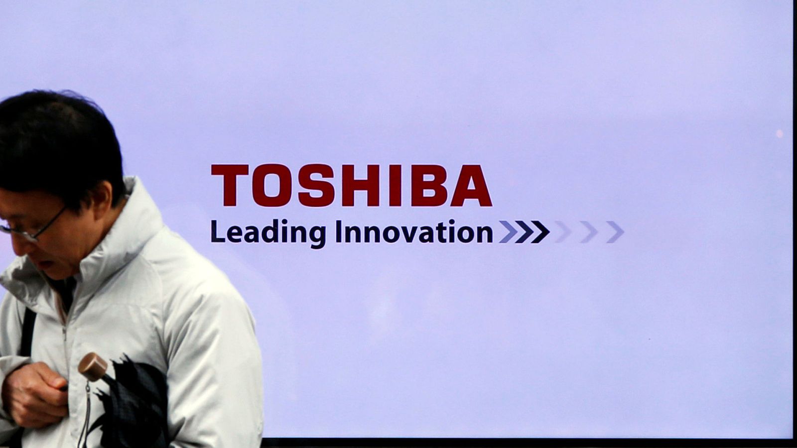 Foto: Un hombre pasa frente a un cartel de Toshiba en Tokio. (Reuters)