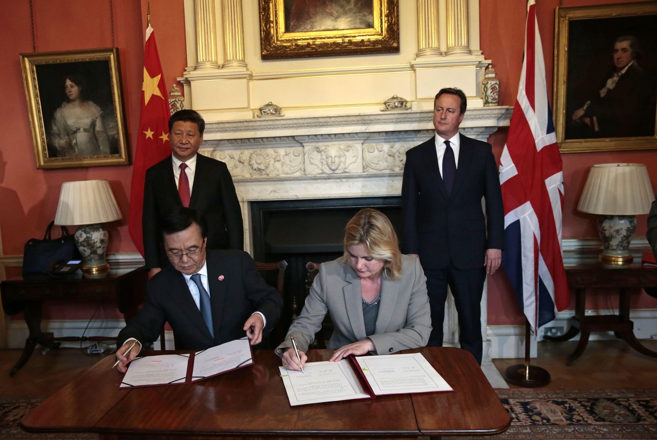 La secretaria de Desarrollo británica firma un acuerdo con su homólogo chino ante la mirada de Xi Jinping y David Cameron, en Londres. (Reuters)