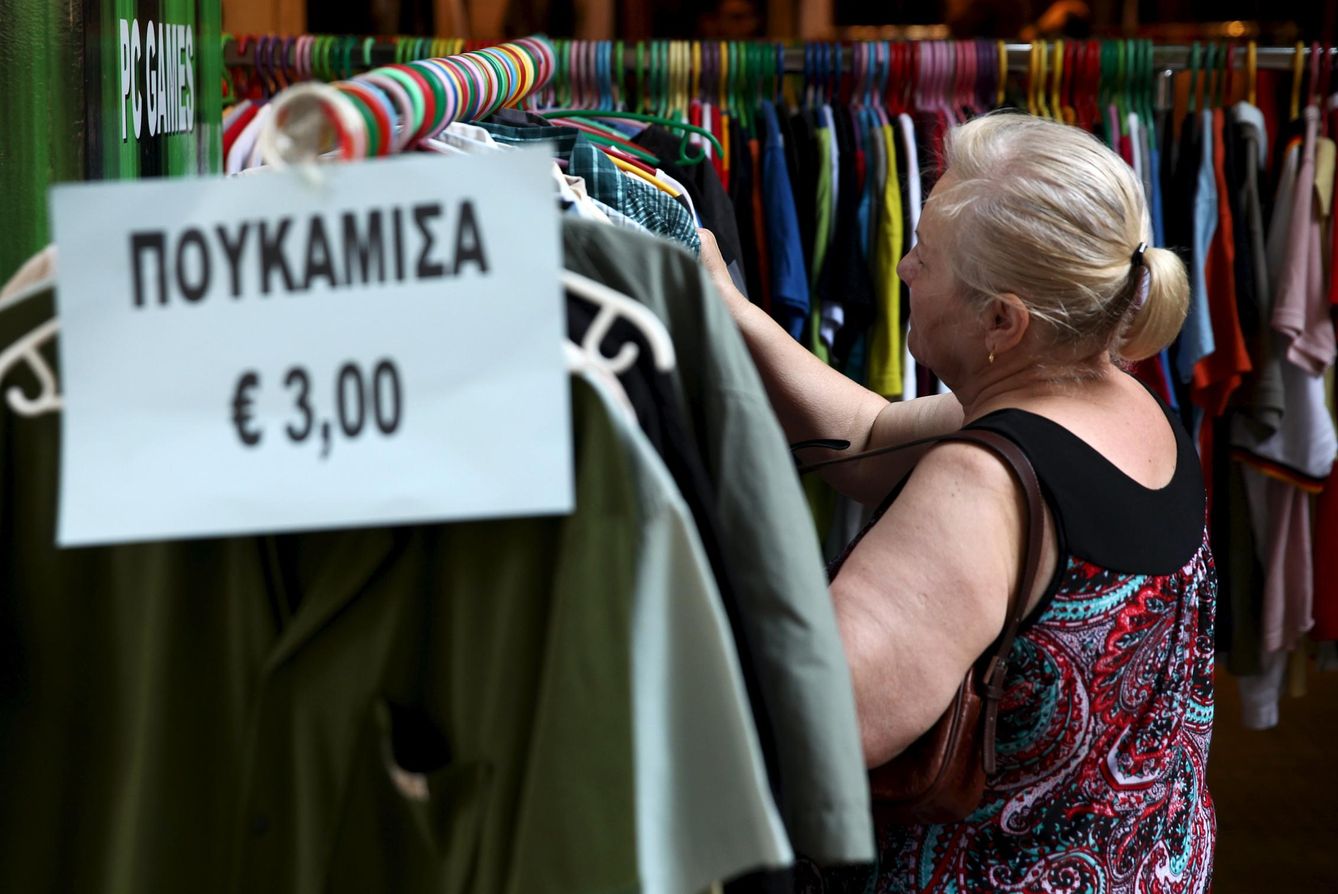 Una mujer examina ropa en una tienda de Atenas (Reuters)