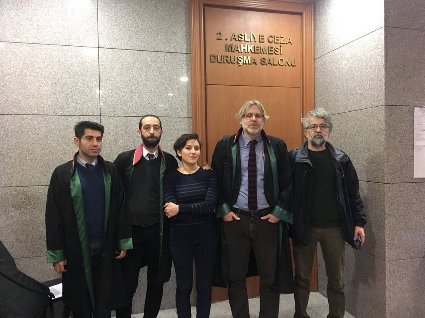 Pelin Ünker (centro) junto a sus abogados y colegas en el tribunal de Estambul que la juzgó
