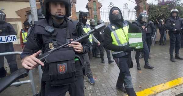Foto: Agentes antidisturbios de la Policía Nacional retiran material del Instituto Can Vilumara de L'Hospitalet de Llobregat durante el referéndum del 1-O. (EFE)