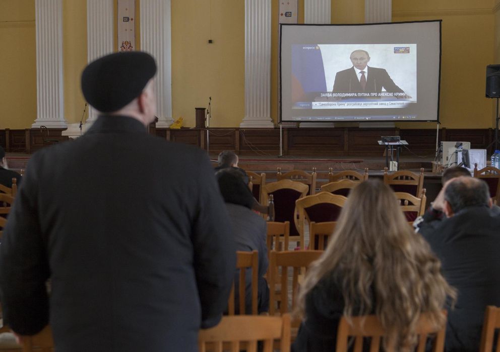 Foto: Varios ucranios, frente a una pantalla en la que se televisa un discurso de Putin. (Reuters)