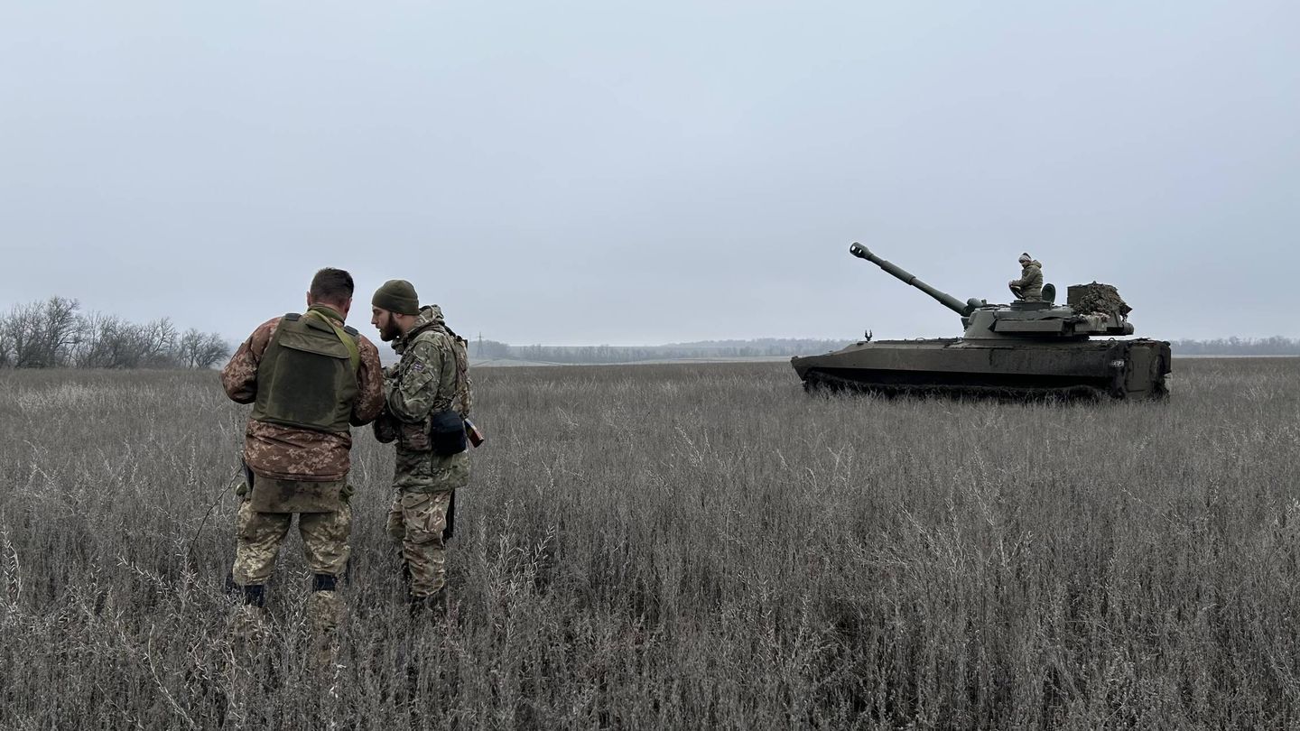 Dos soldados ucranianos hablan antes de disparar contra posiciones rusas en algún punto del Donbás. (Alicia Alamillos)