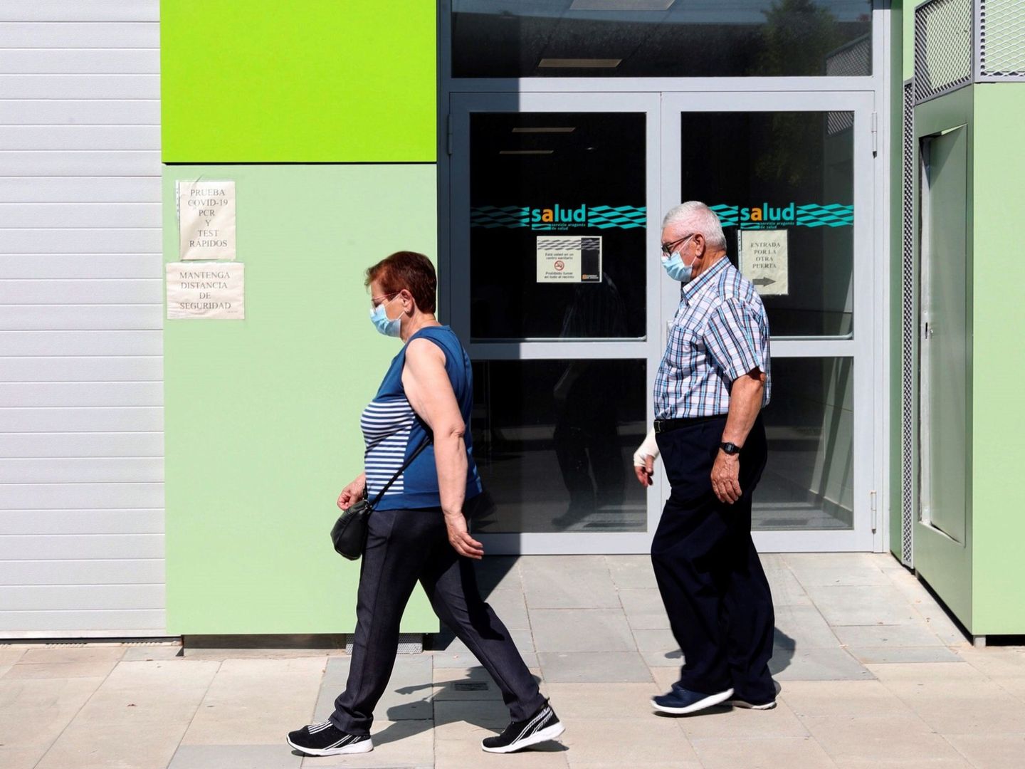 Dos ancianos, frente al Centro de Salud de Binéfar (Huesca), donde cuatro comarcas han vuelto a fase 2. (EFE)