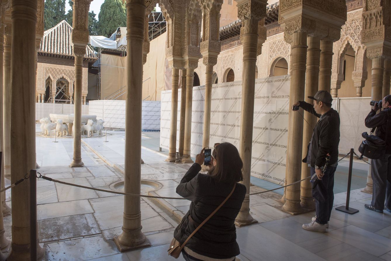 Unos turistas fotografían el Patio de los Leones de la Alhambra de Granada. (EFE)