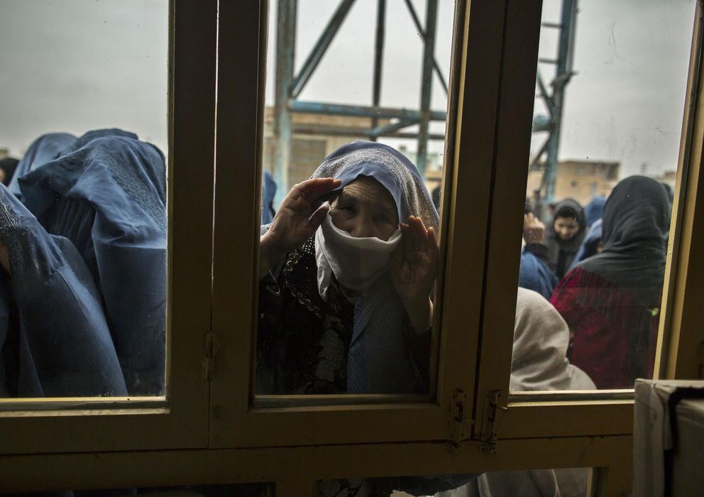 Foto: Una mujer afgana mira el interior de un centro electoral mientras espera para votar en Mazar-i-Sharif (Reuters).