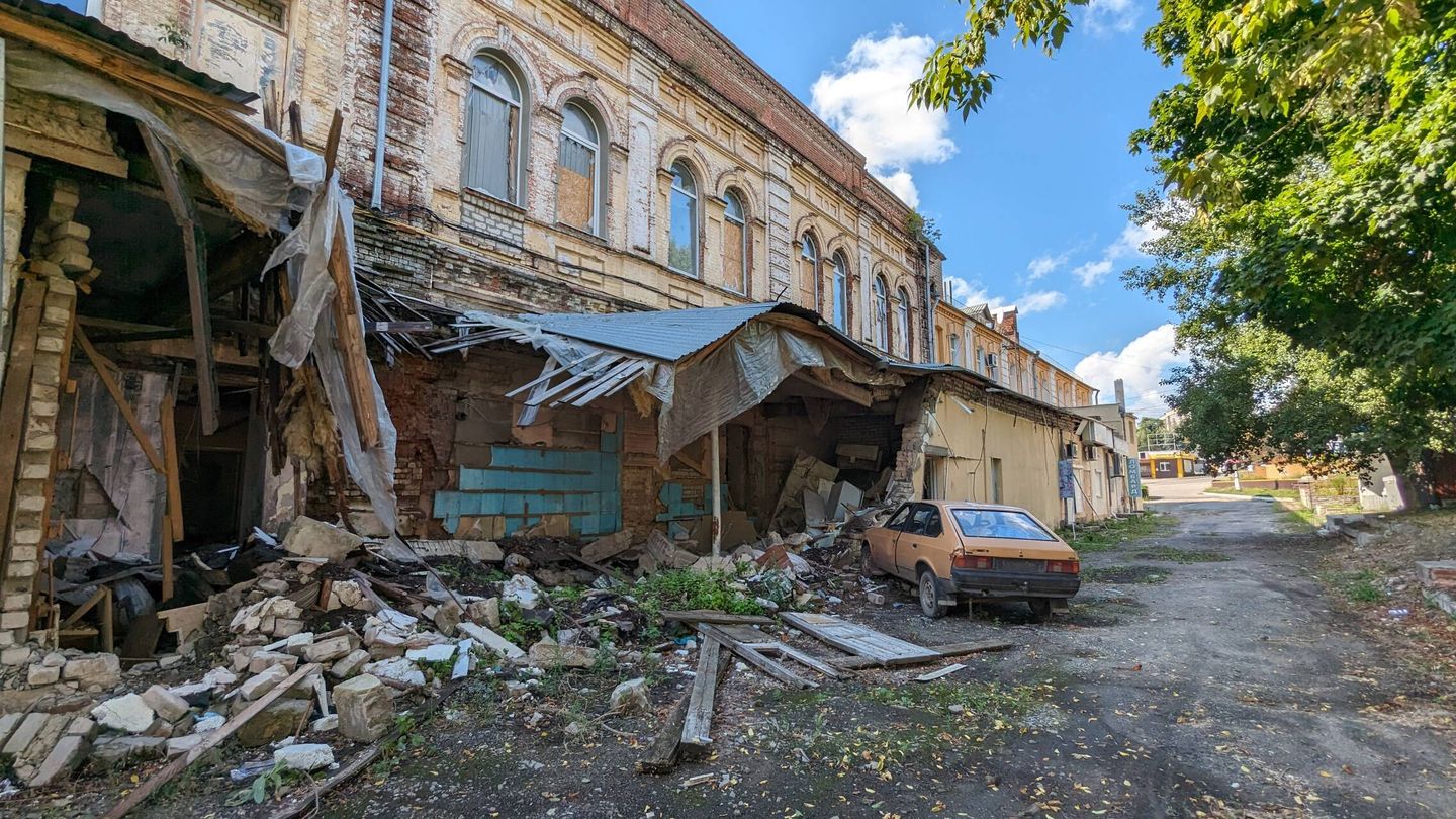 Un comercio destruido en Kupiansk. El coche, afectado por la explosión, estaba cargado de víveres. (Alicia Alamillos)