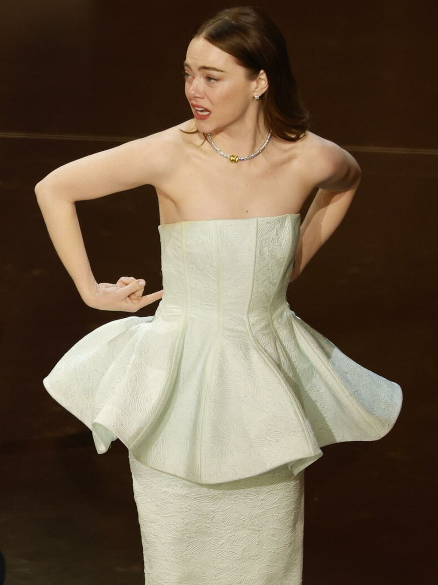Emma Stone, al subir a recoger su premio Oscar, nota que su cremallera se ha roto. (EFE)