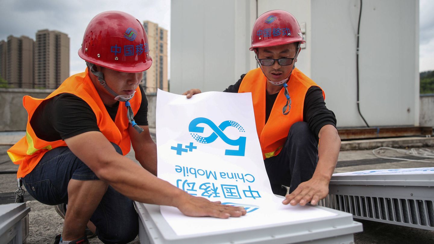 Trabajadores colocan un letrero de China Mobile 5G en un equipo de la ciudad china de Fenggang. (Reuters)