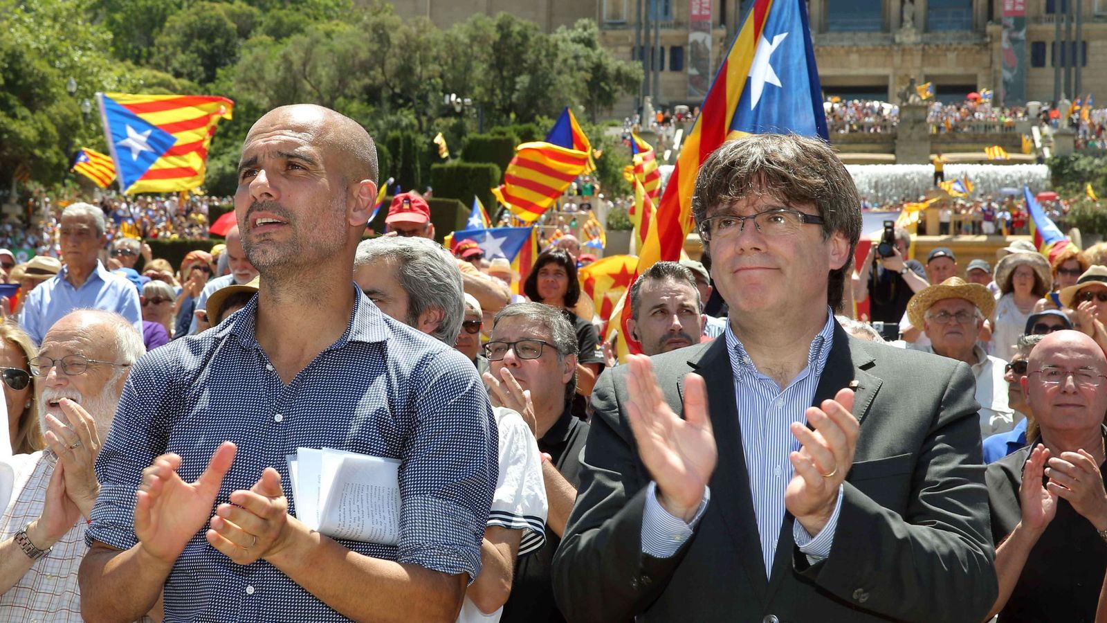 Foto: Pep Guardiola, junto a Carles Puigdemont, aplaude al finallizar un acto con el lema 'Referéndum es democracia'. (EFE)