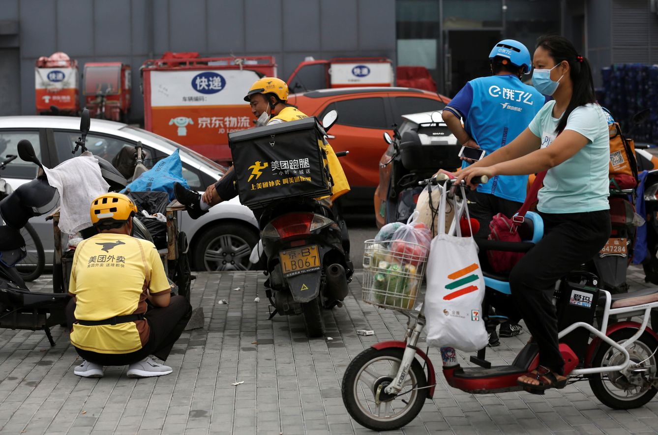 Foto: Repartidores de Meituan, a la espera de un pedido. (Reuters)