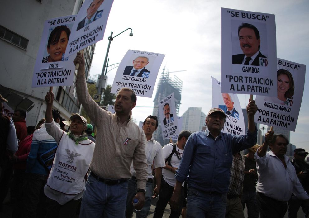 Foto: Manifestantes muestran fotos de senadores durante una protesta contra la reforma energética. (Reuters)