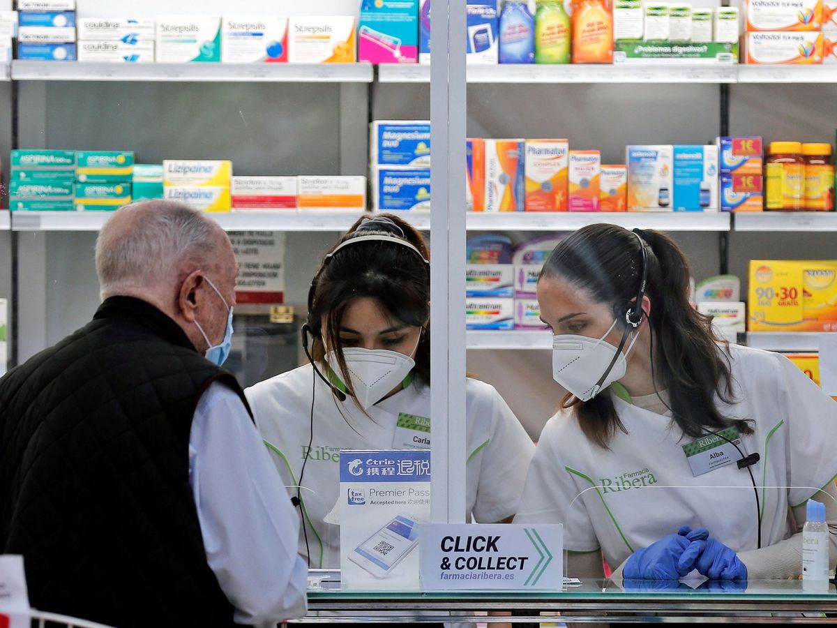 Foto: Dos empleadas de una farmacia atienden a un cliente. (EFE)
