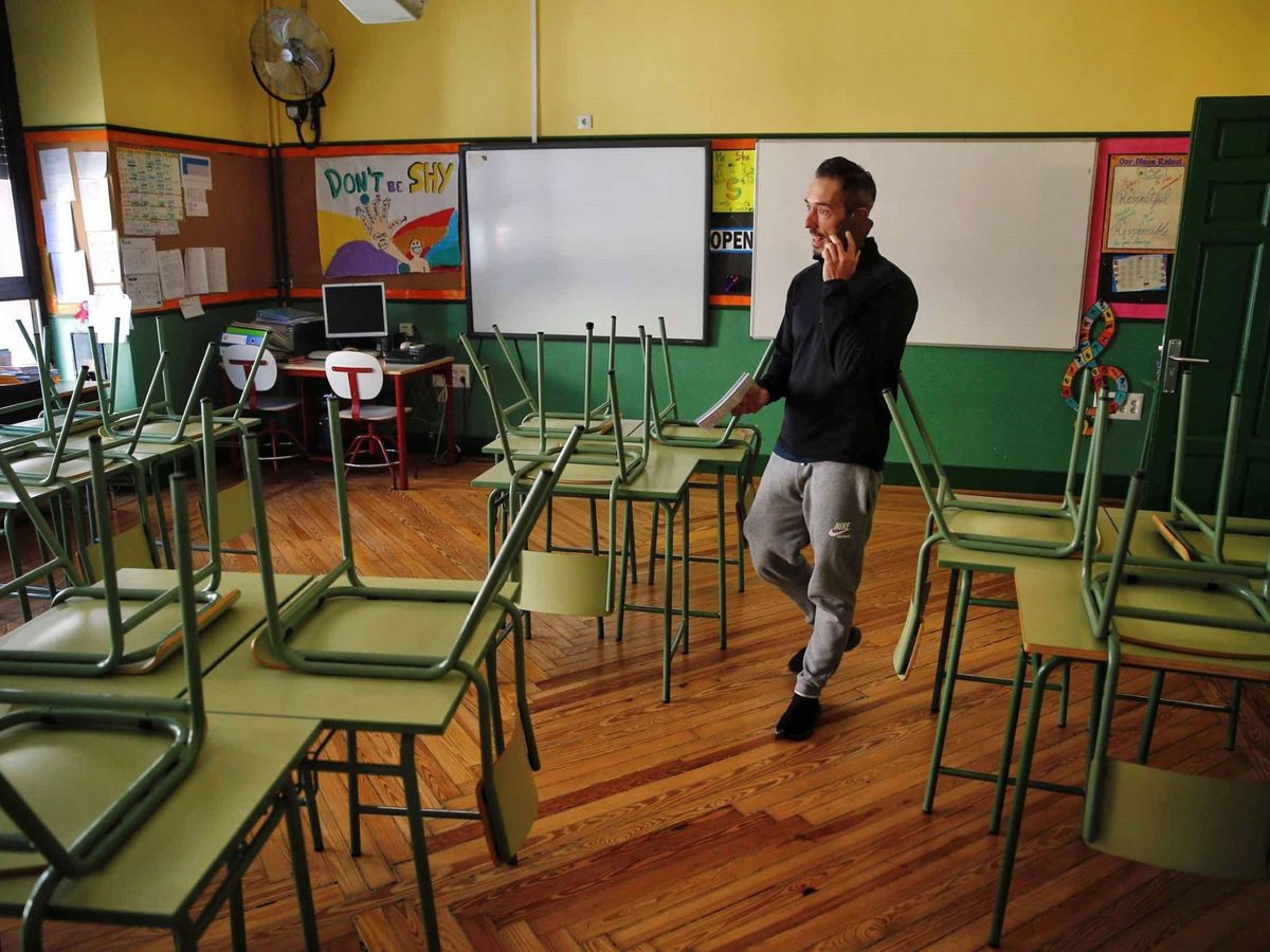 Foto: Un docente habla por su teléfono móvil en un aula desierta en el colegio público Rufino Blanco en Madrid. (EFE/Campos)
