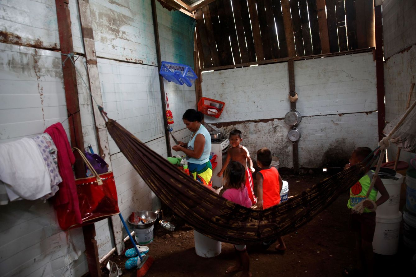 Una mujer, acompañada por sus hijos, prepara alimentos en Ciudad de Panamá (Panamá). (EFE)