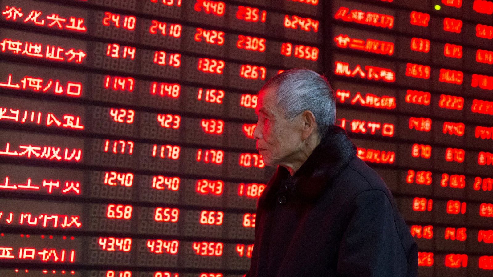 Foto: Un inversor asiático observa los valores en rojo en un panel informativo. (Reuters)