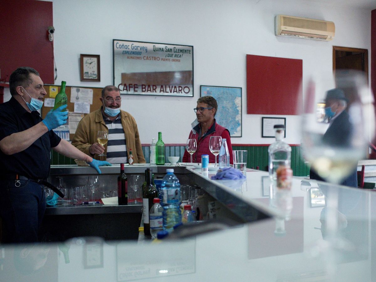 Foto: Varios clientes conversan en el interior de una bar de Ourense. (EFE)