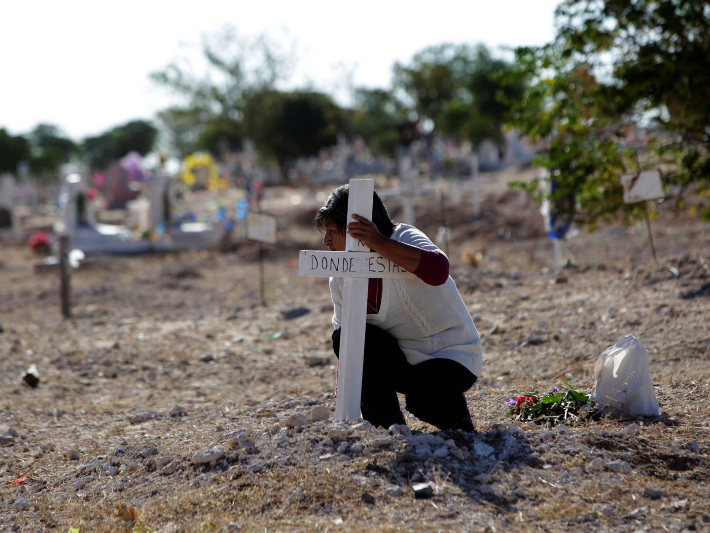 Una mujer pone una cruz en el cementerio de San Rafael durante el Día de los Muertos, en las afueras de Ciudad Juárez. (Reuters)