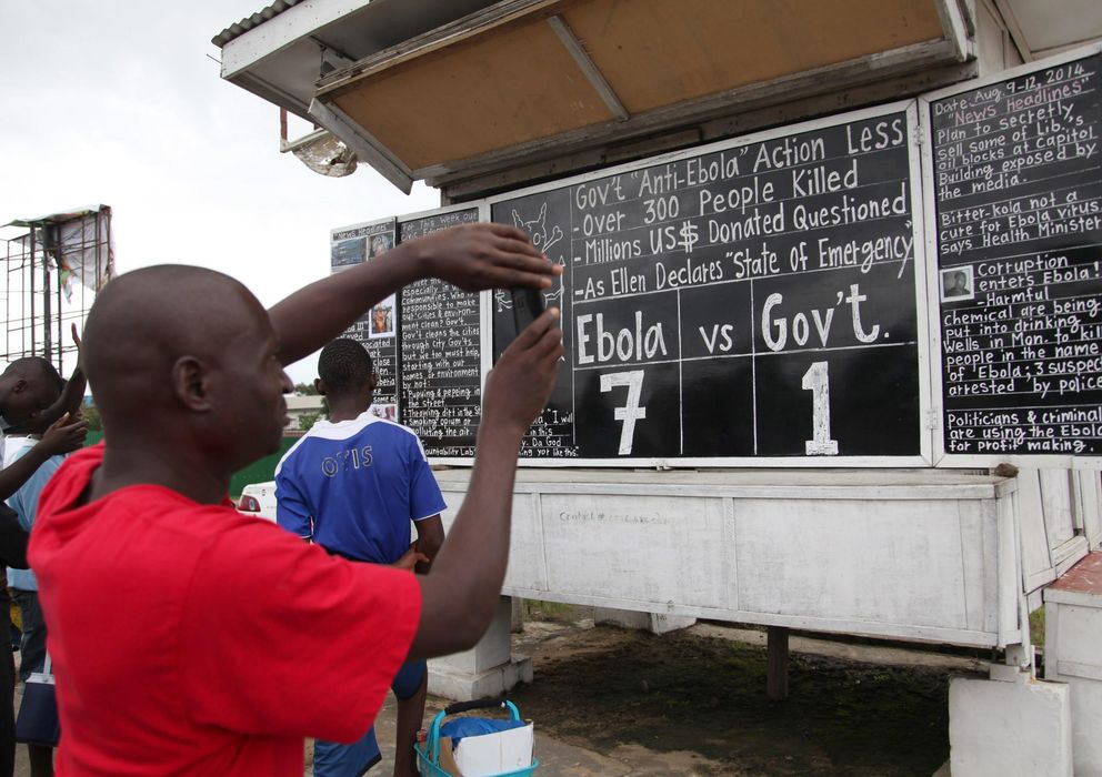 Foto: Liberianos leyendo una pizarra con los datos del ébola. (Efe)