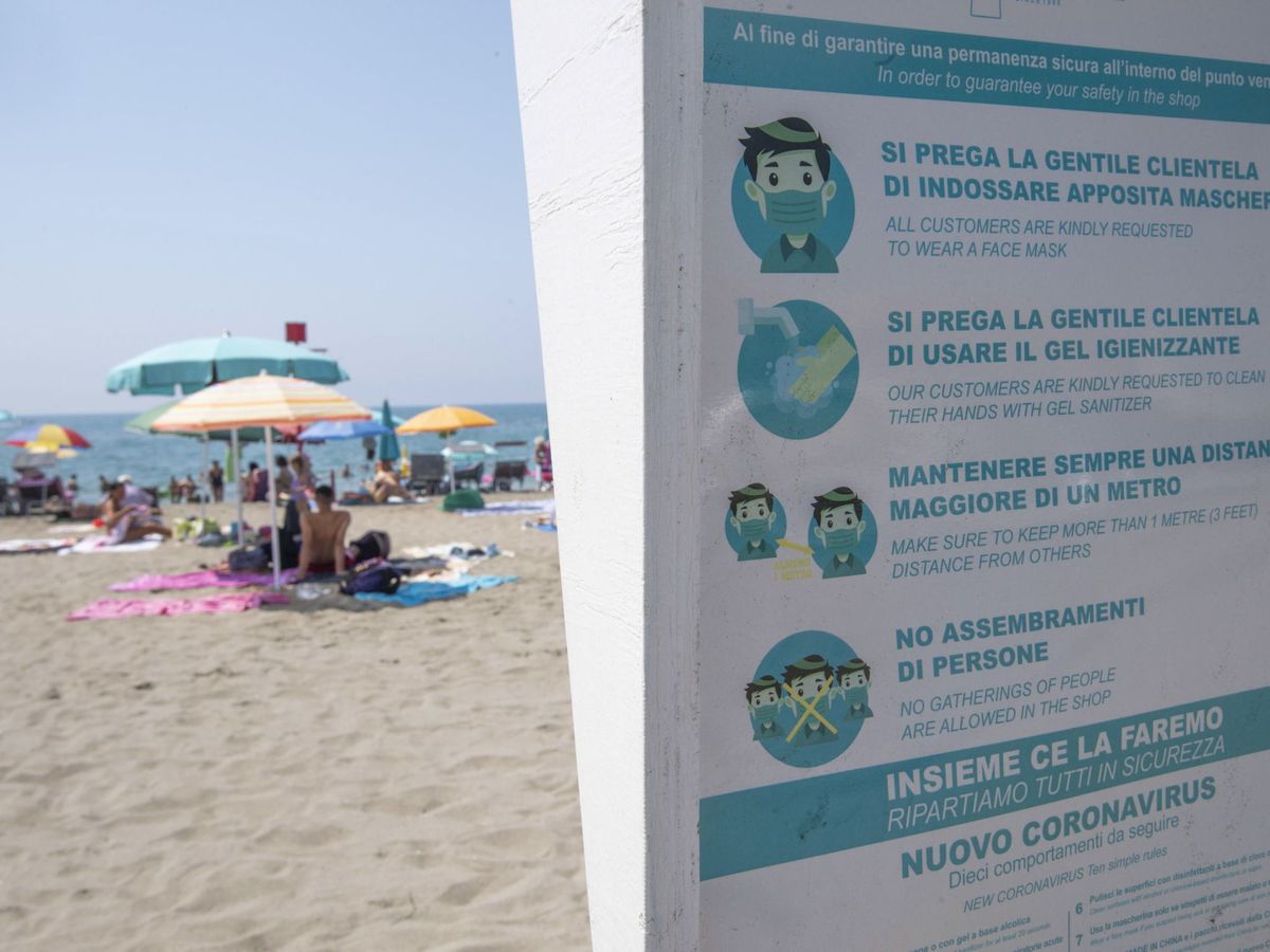 Foto: Indicaciones sobre el covid en la playa de Ostia. (EFE)