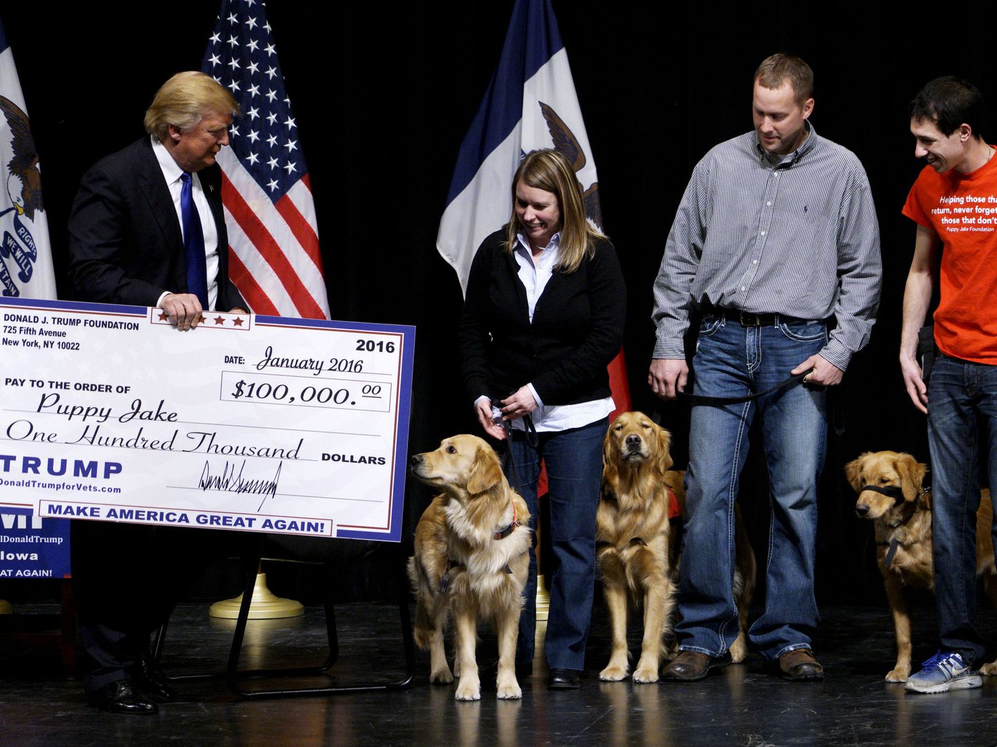 Donald Trump, entonces candidato presidencial, entrega un cheque de 100.000 dólares de la Fundación Trump a una ONG que ayuda a veteranos del ejército mediante perros adiestrados, en enero de 2016. (Reuters)