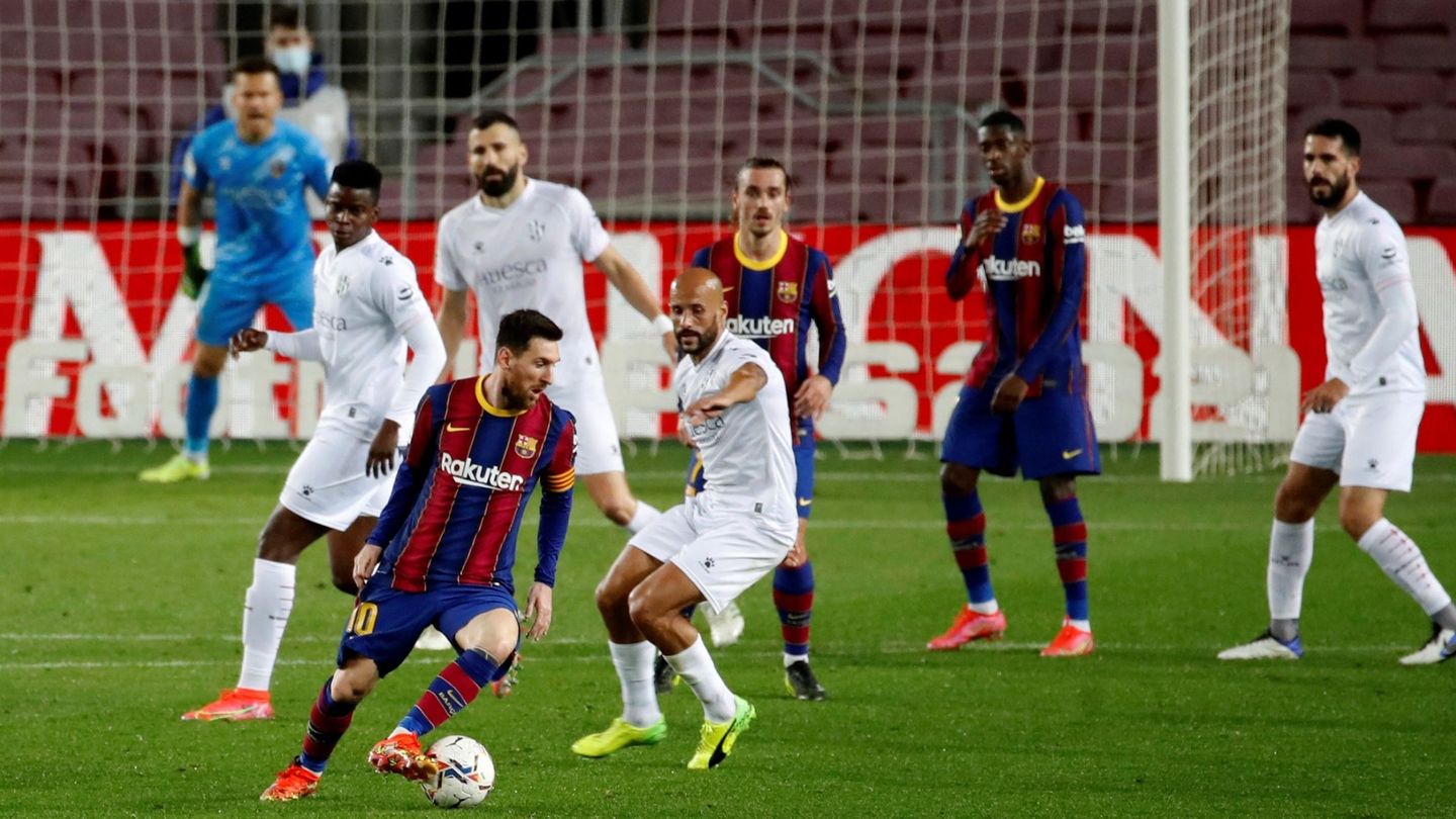 Leo Messi protege el balón ante el acoso de los defensores oscenses. (Reuters)