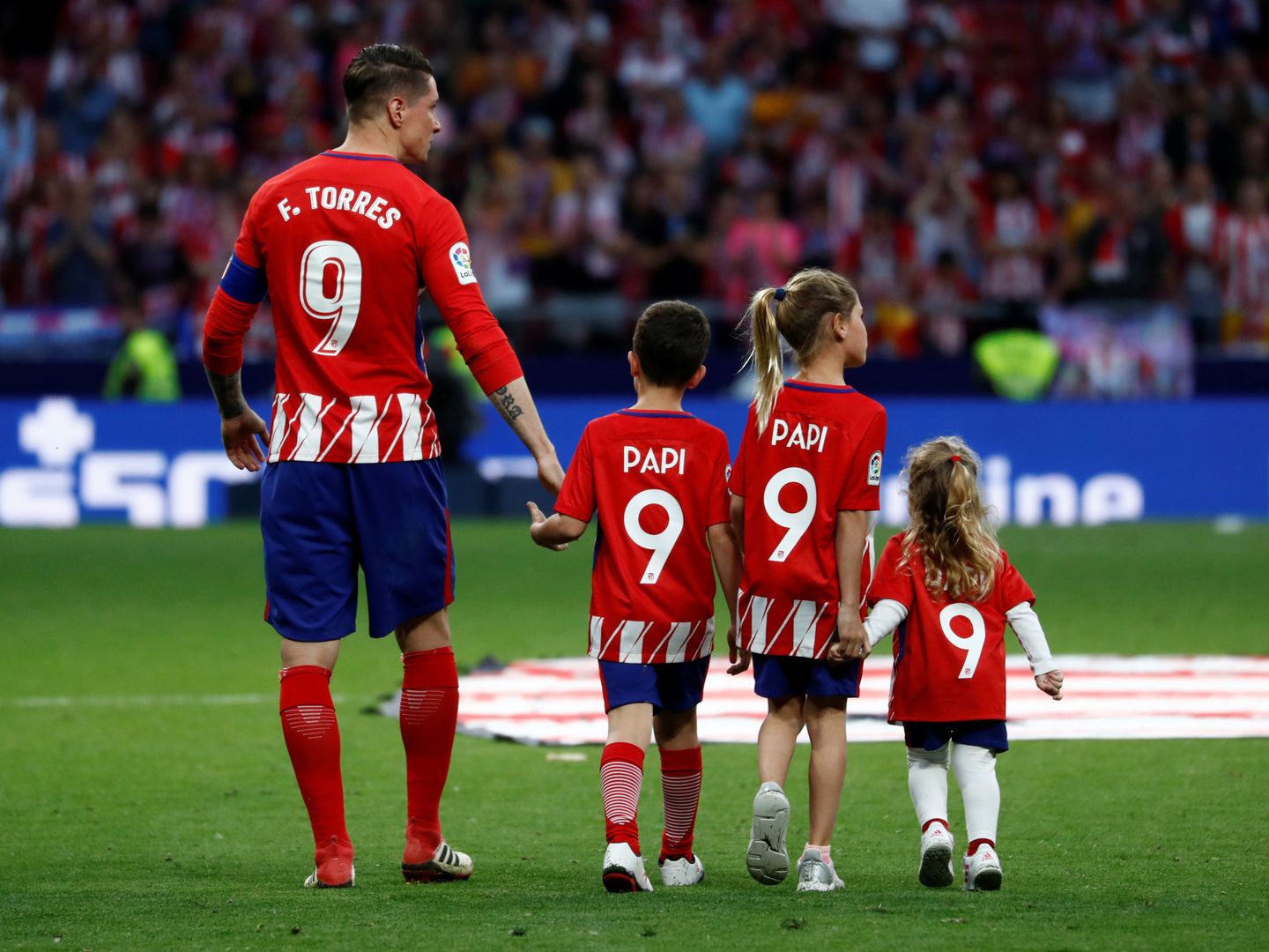 Fernando Torres con sus hijos en el césped del Metropolitano. (Efe)