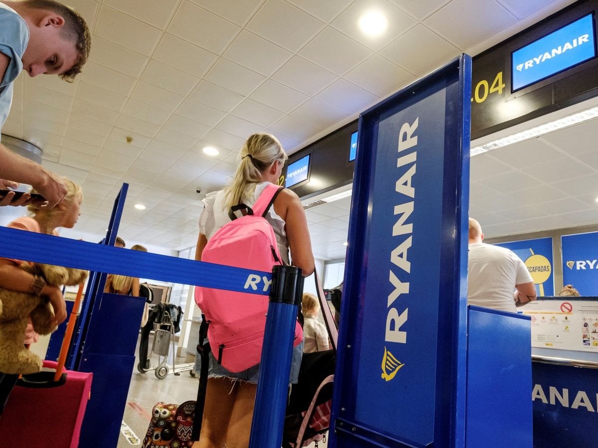 Foto: Varios pasajeros esperan a facturar su equipaje en los mostrador de Ryanair en el aeropuerto de Gran Canaria. (EFE)