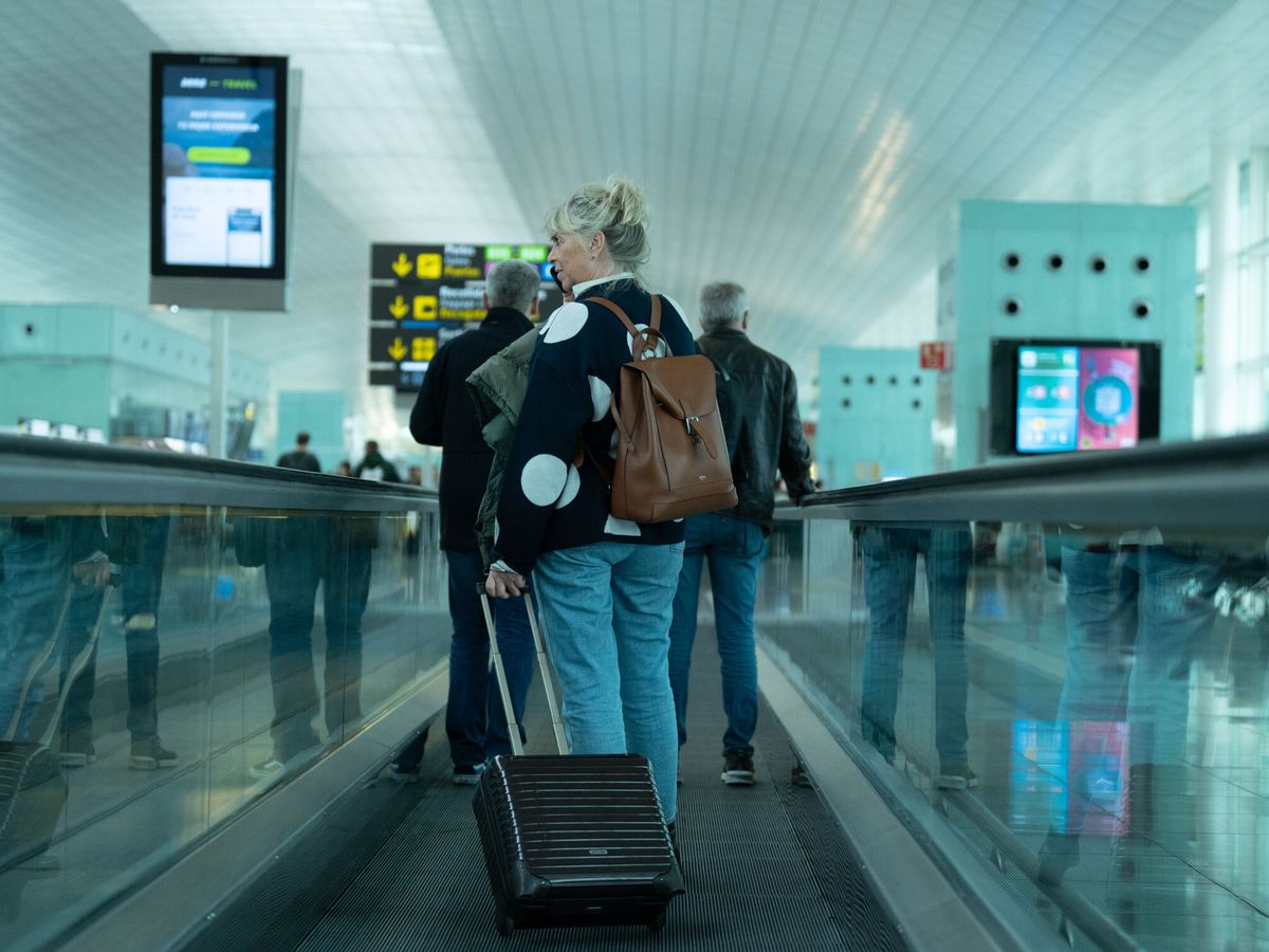 Foto: Una mujer en el aeropuerto de El Prat. (Europa Press/David Zorrakino)