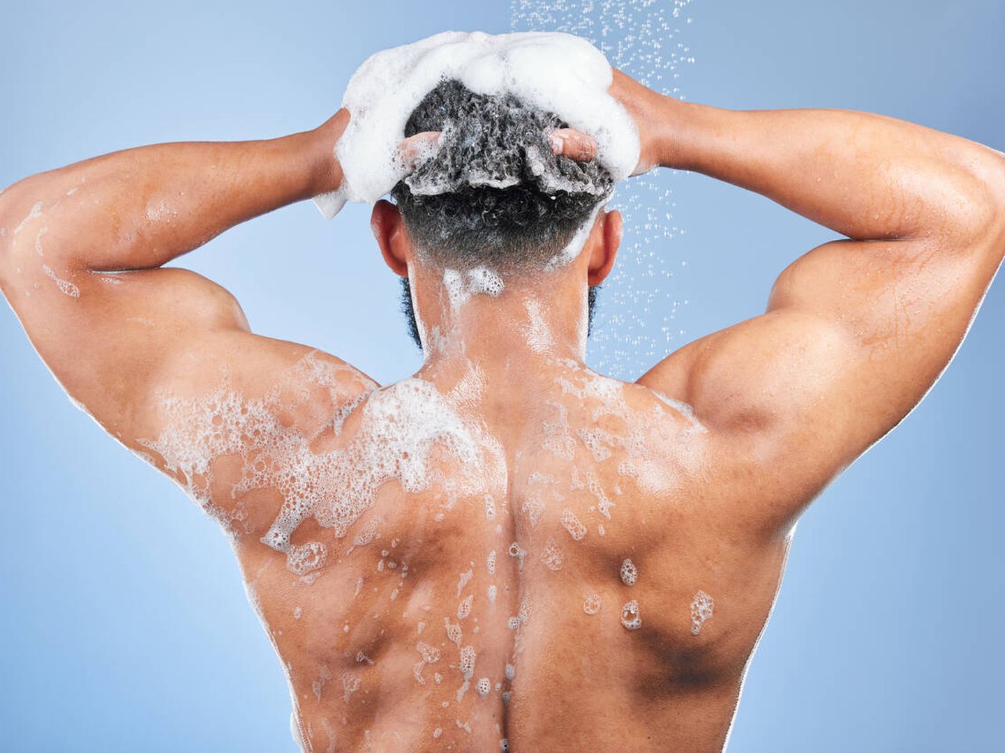Un hombre de espaldas lavándose el pelo (iStock)