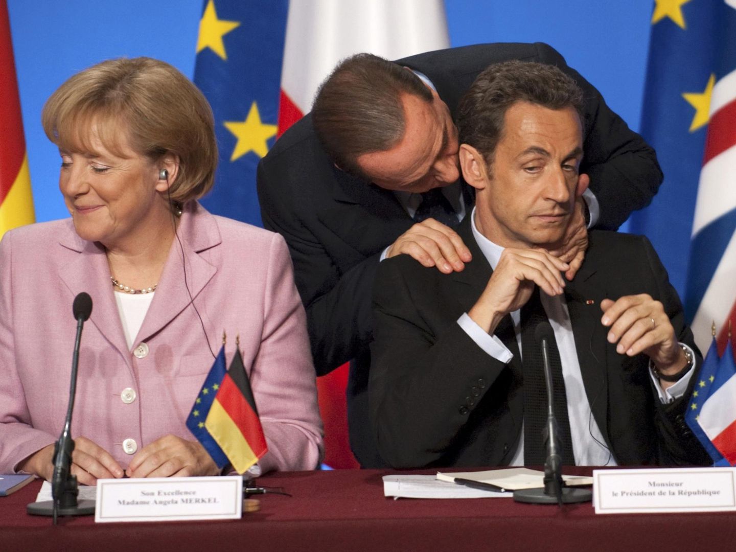 Berlusconi se acerca a Nicolas Sarkozy, junto a la canciller alemana Angela Merkel. (Reuters)