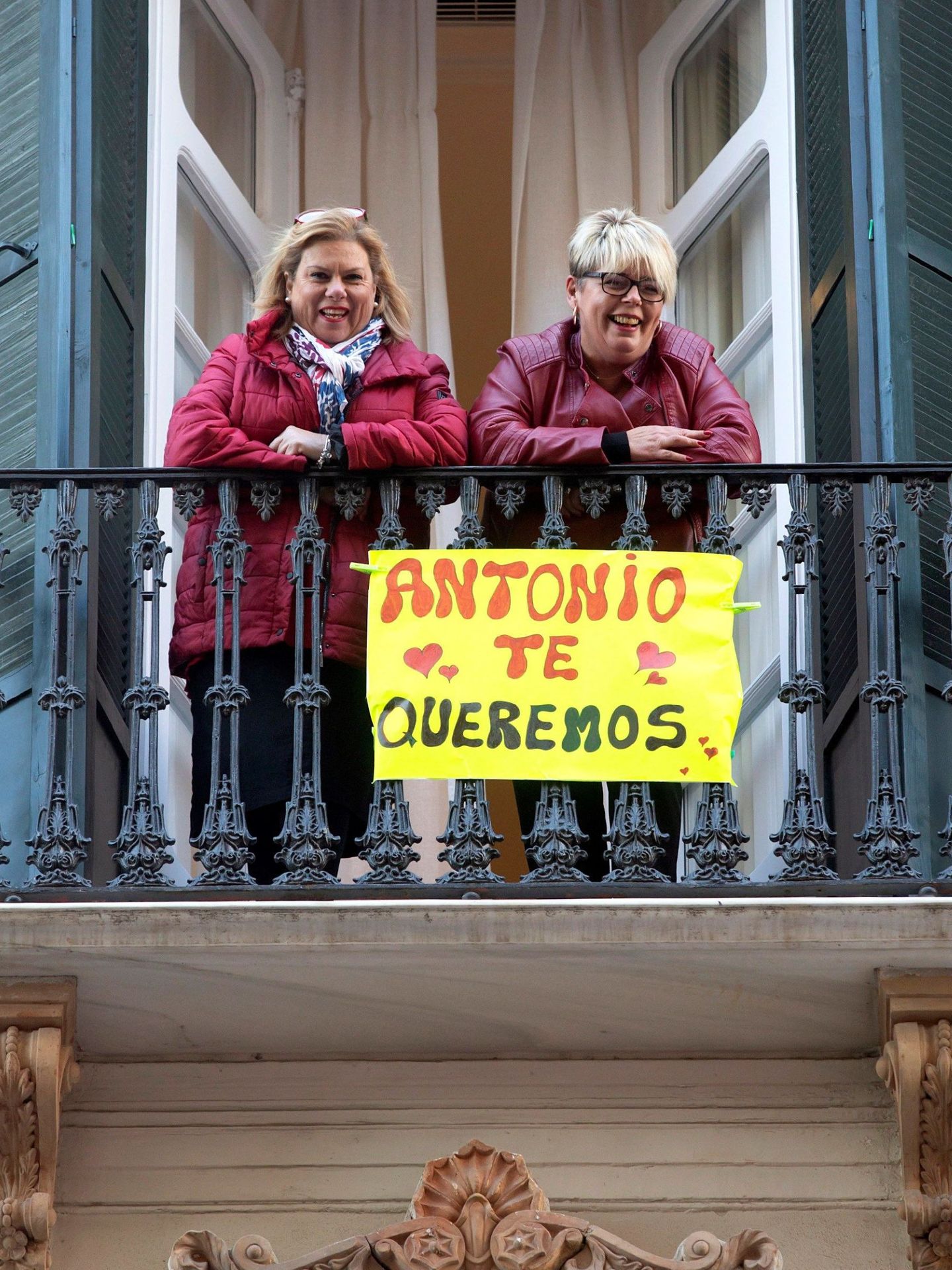 Dos vecinas saludan desde un balcón al actor Antonio Banderas mientras posa antes del pase del musical 'A Chorus Line'. (EFE)