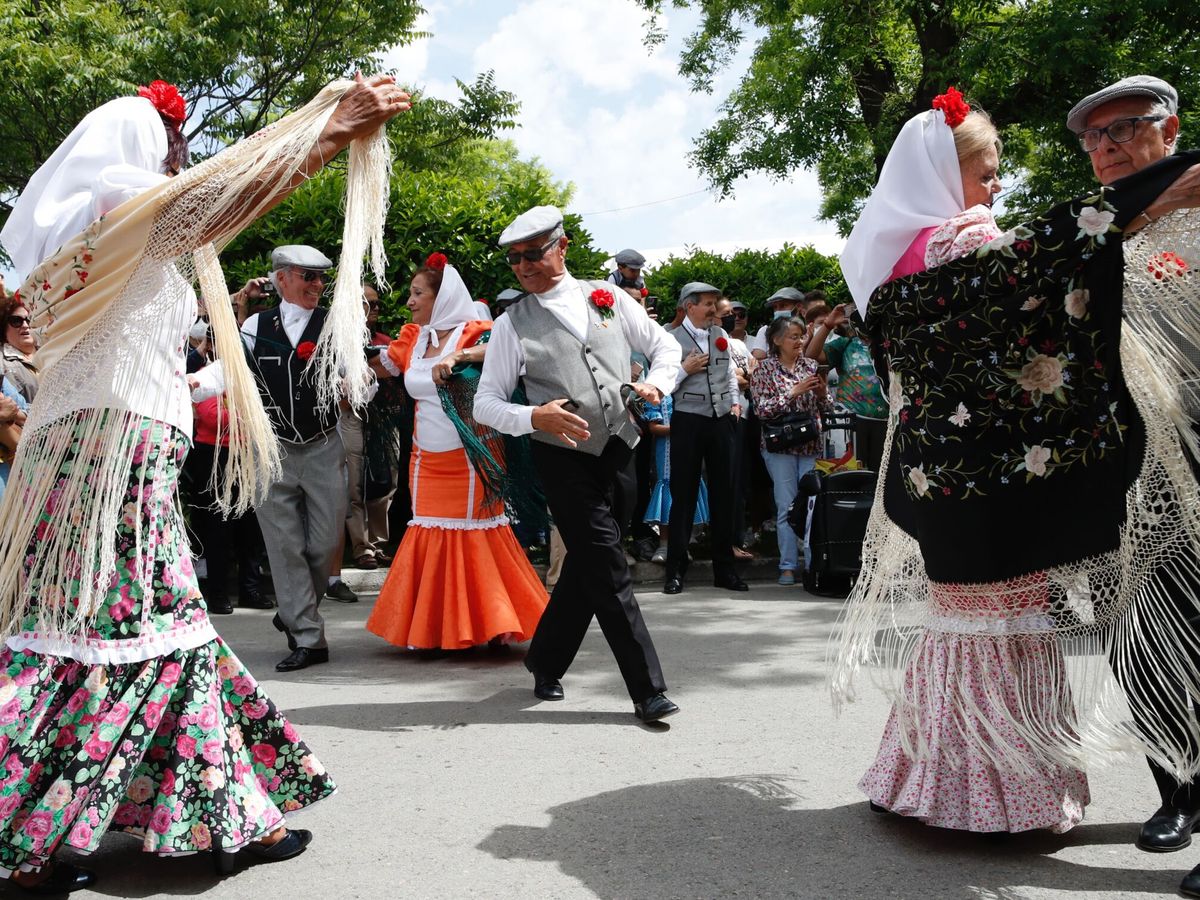 Foto: Varios chulapos bailan un chotis en la Pradera de San Isidro. (EFE/Javier López)