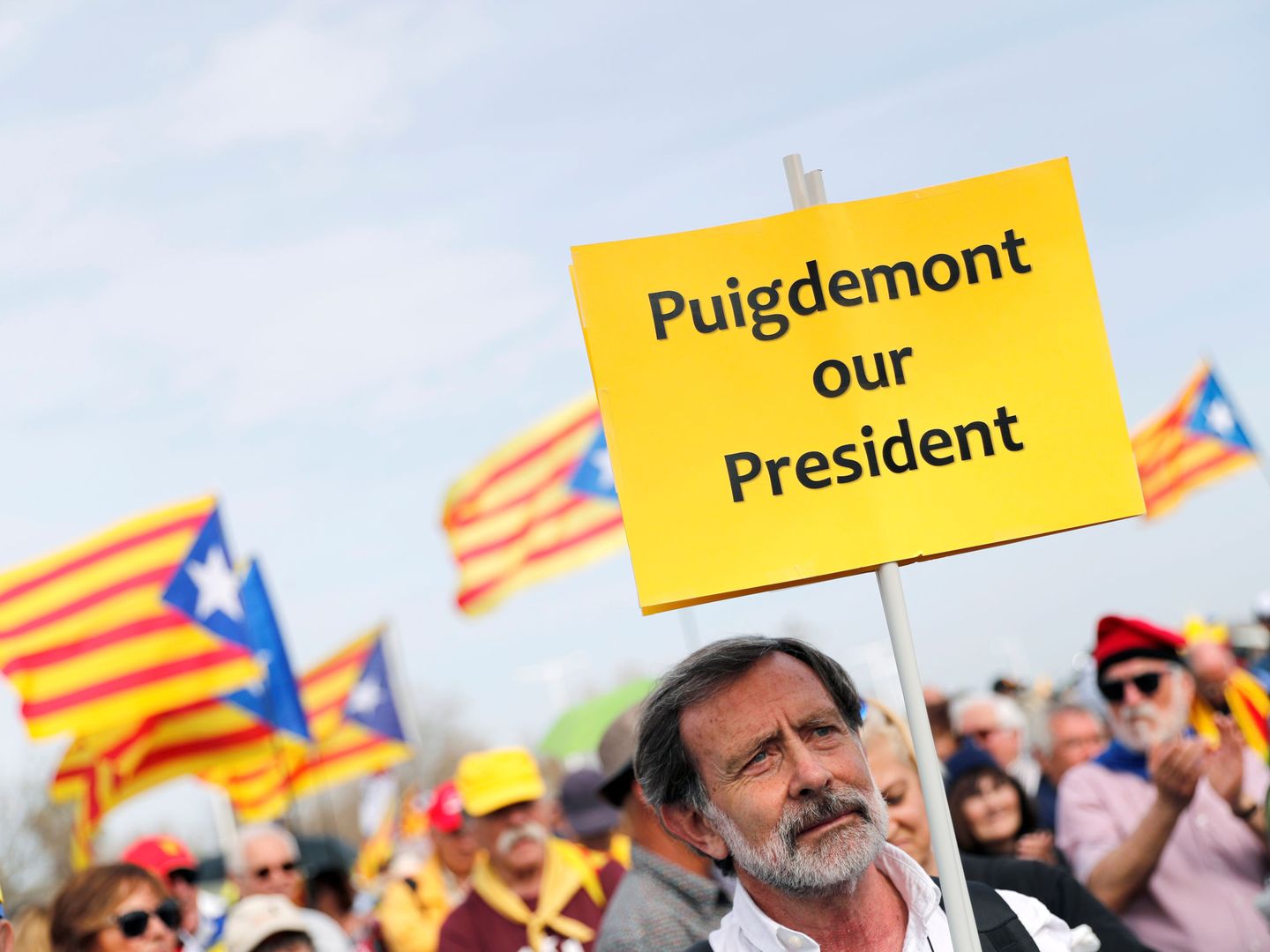 Un manifestante sostiene un cartel en favor de Puigdemont durante un acto en Perpignan. (Reuters)