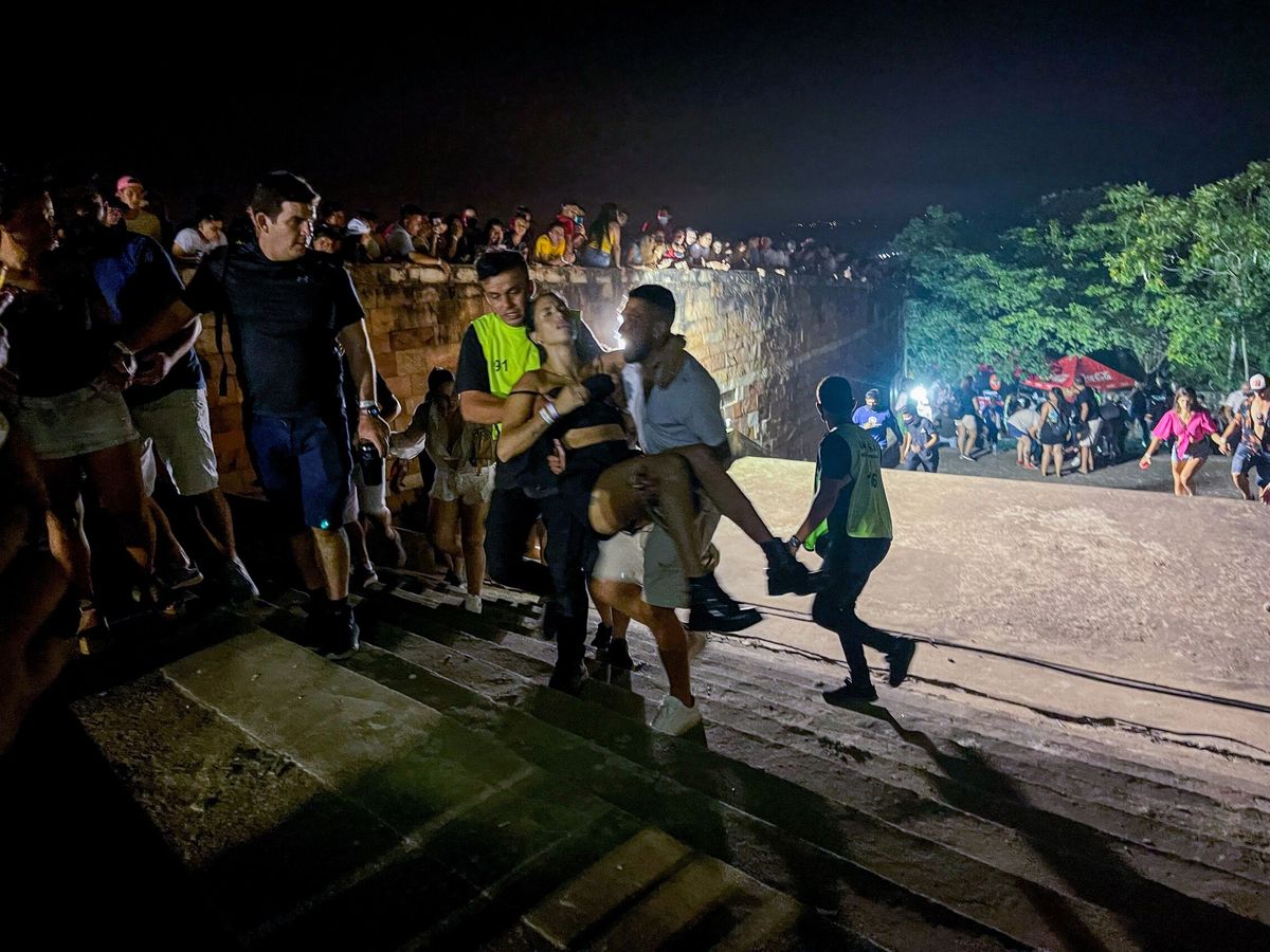 Foto:  Unos hombres cargan a una mujer afectada tras un tiroteo en un concierto en Paraguay. (EFE/Stringer)