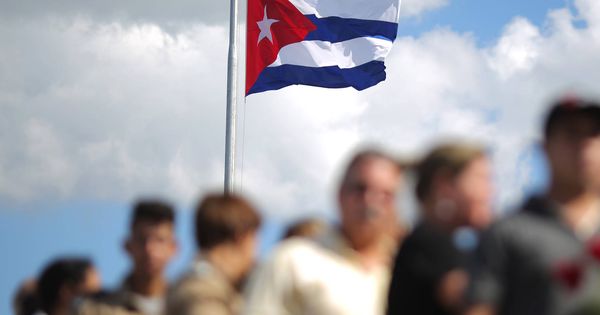 Foto: Una bandera cubana sobre un grupo de personas que esperan para rendir tributo al difunto Fidel Castro. (Reuters)