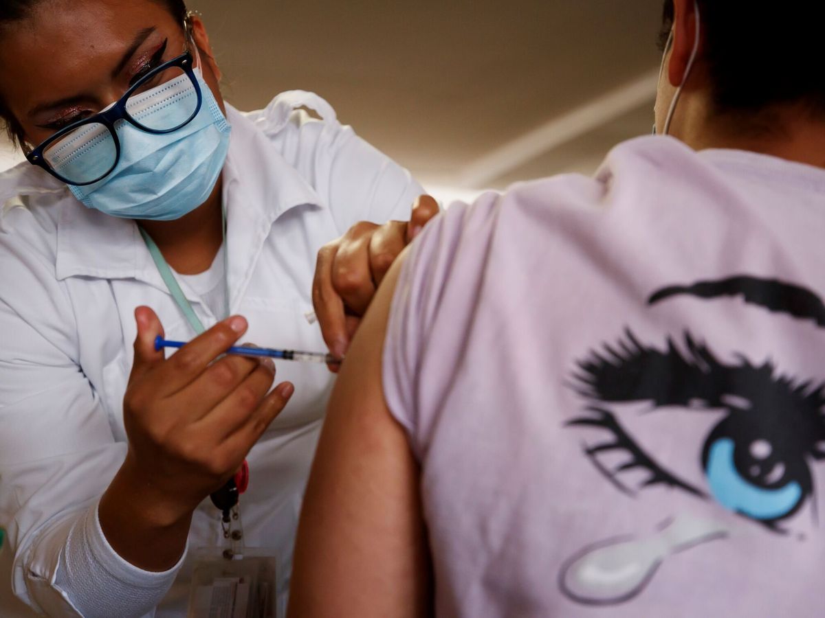 Foto: Una enfermera pone una vacuna. (EFE/José Méndez)