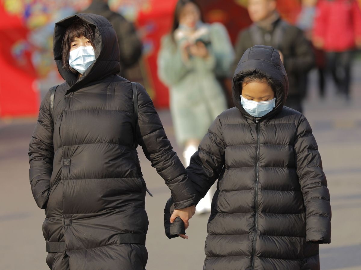 Foto: Dos mujeres caminan con máscara en Pekín. (Reuters)