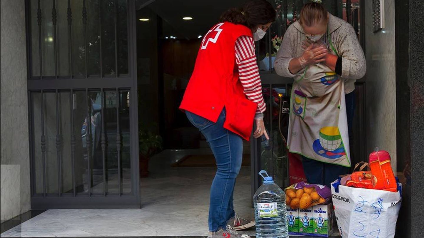 Una voluntaria de Cruz Roja entrega un paquete solidario. (Cruz Roja)