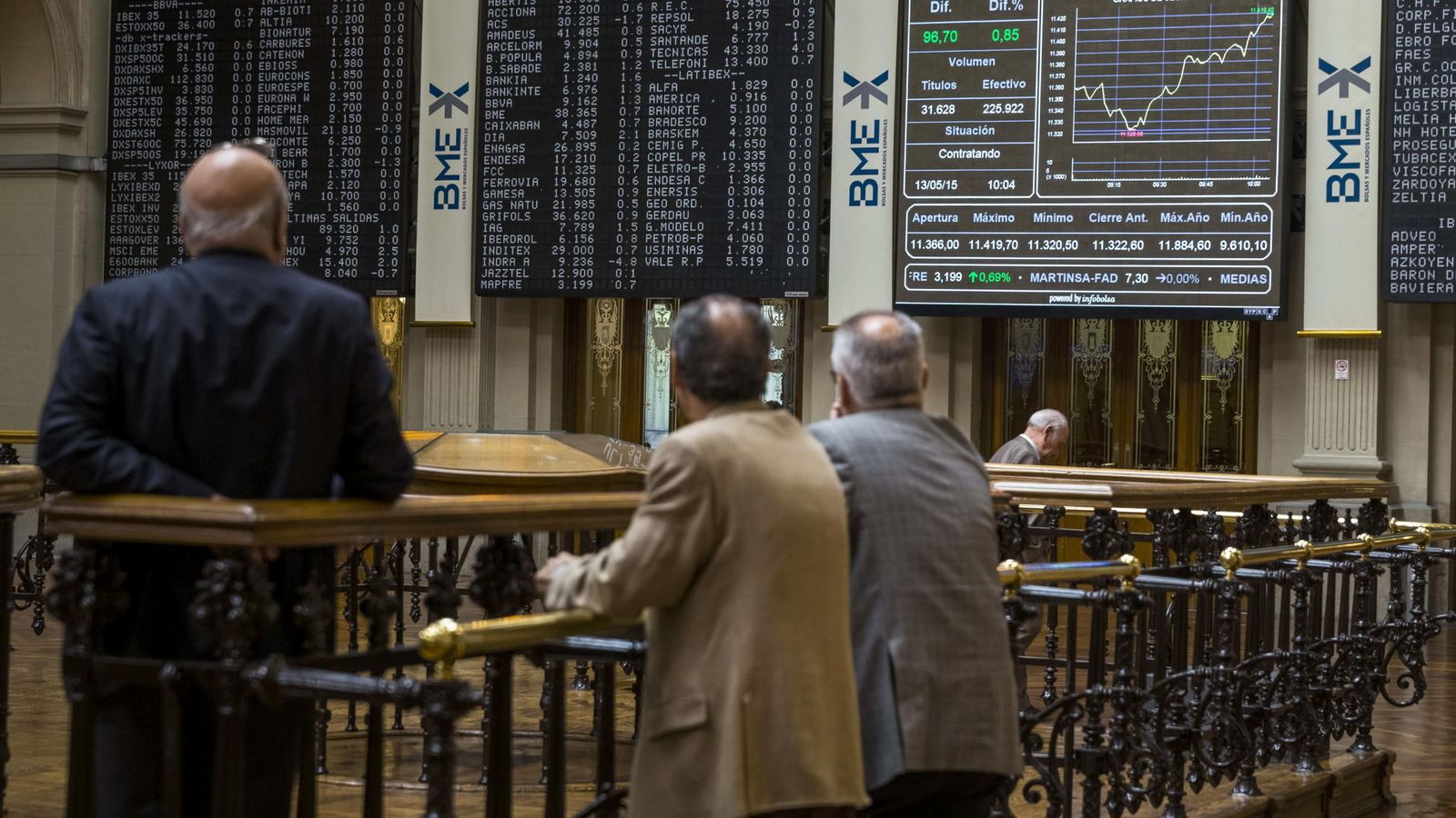 Foto: Tres hombres observan las pantallas de la Bolsa de Madrid. (EFE)